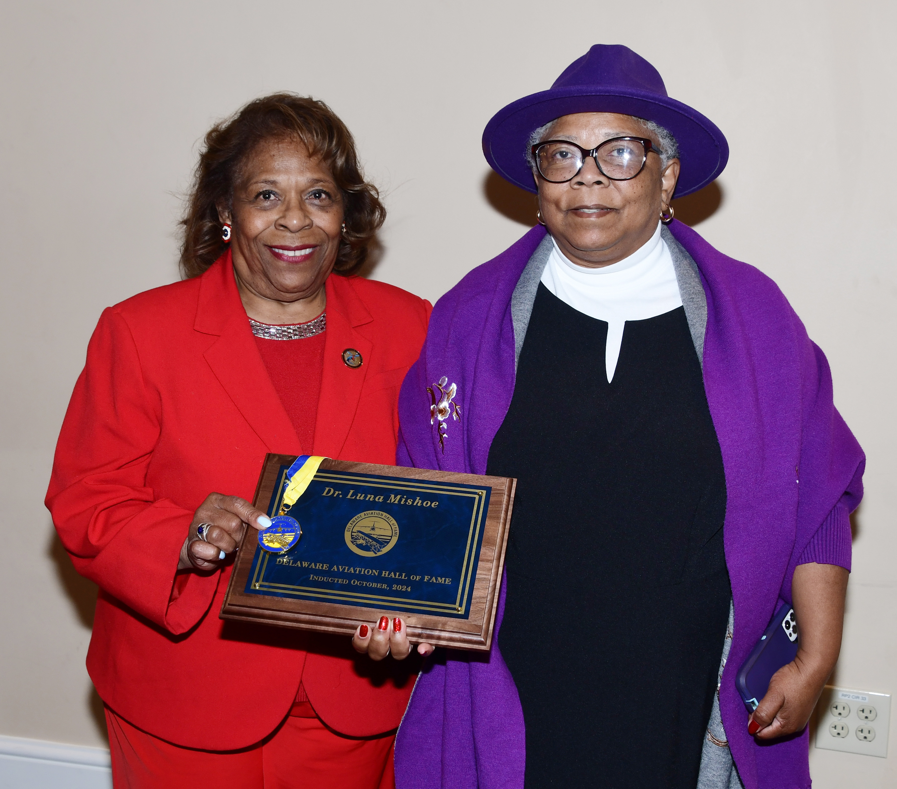 Dr. Wilma Mishoe and her sister Rev. Rita Paige show the induction plaque and medal presented posthumously to Dr. Luna Mishoe. 