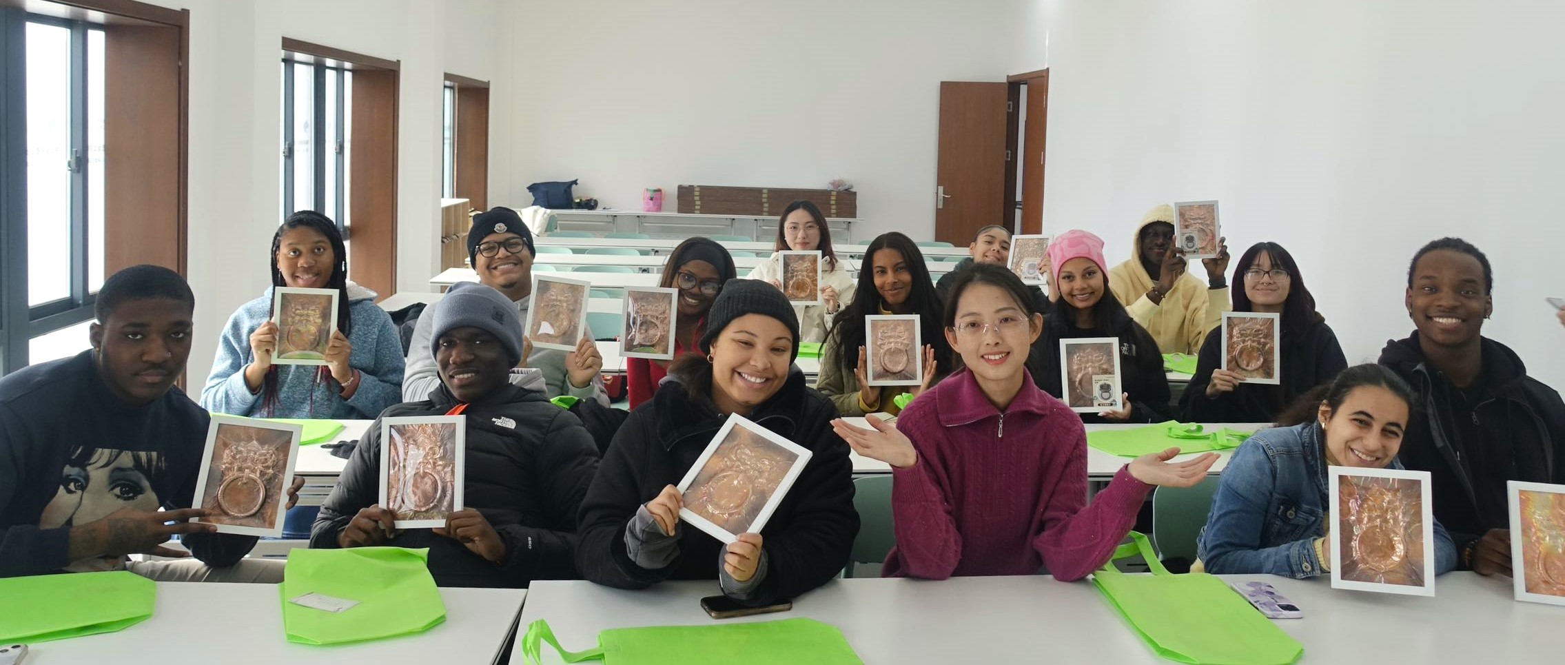 The visiting DSU students show their copper engraved lion head door knocker they craft in a Chinese workshop.