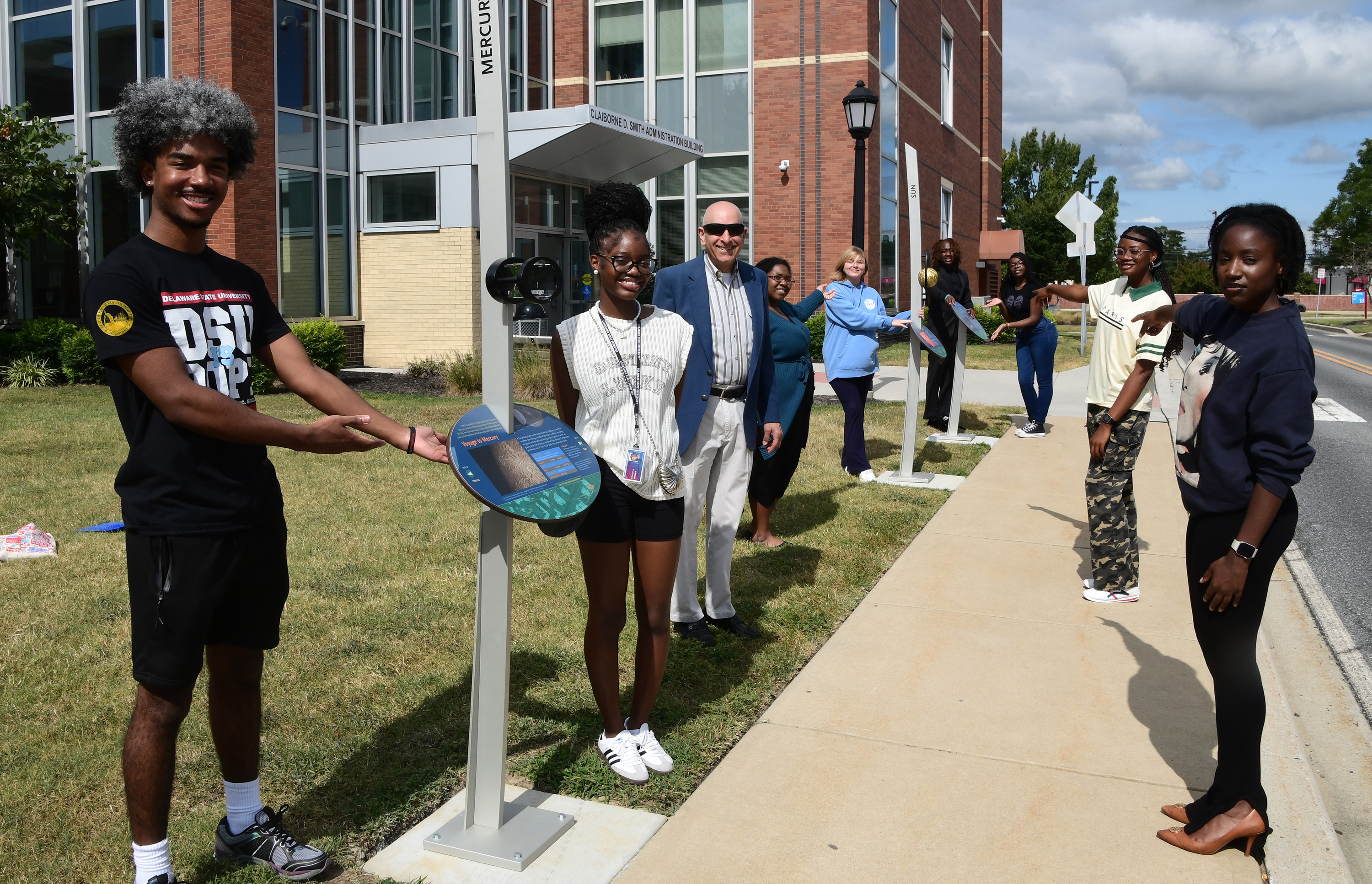 Some DSU students point out several of the Voyage exhibition stations installed new the south end of the Admin Building.