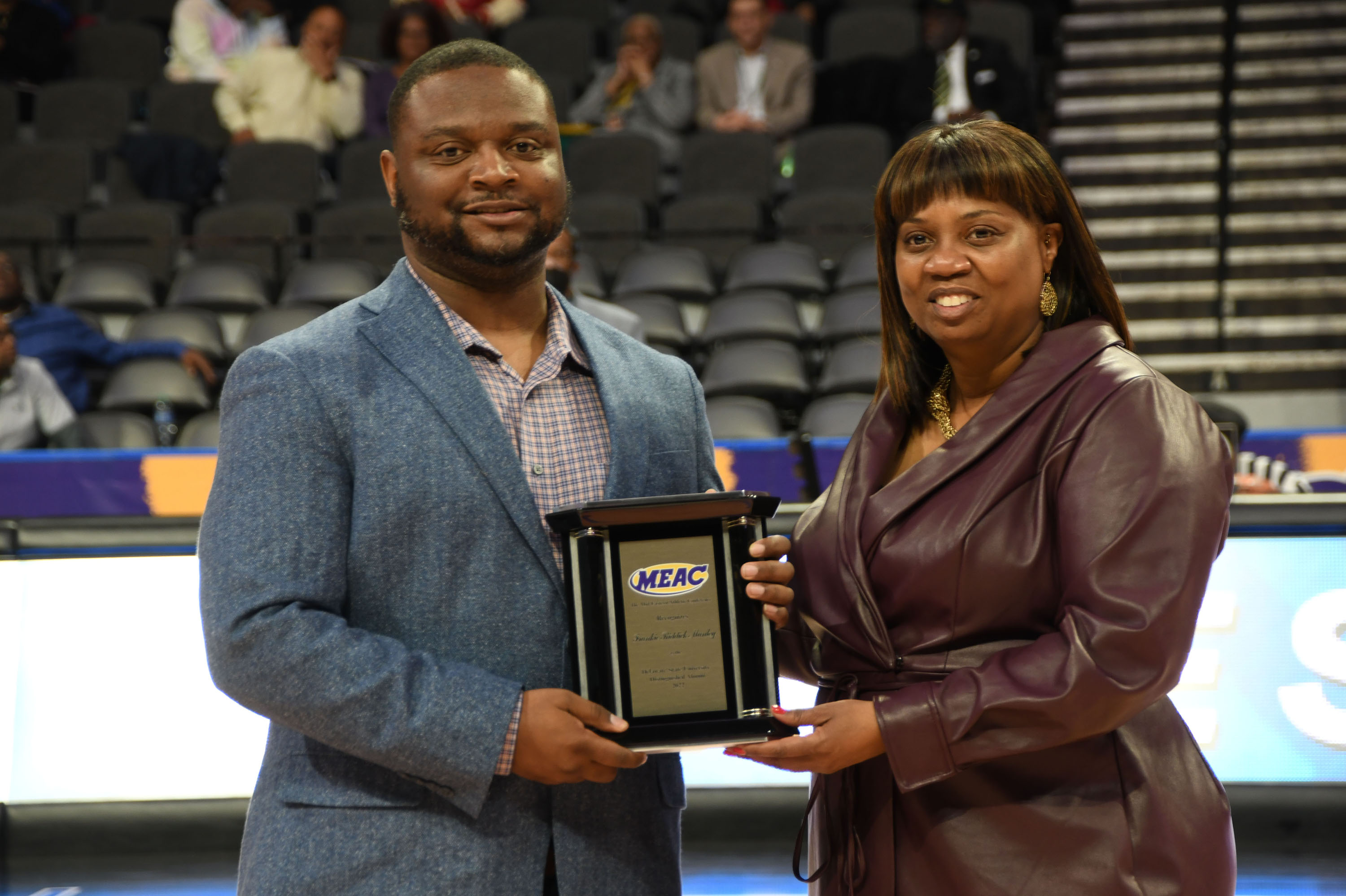 Darius Manley, son of Frankie Manley, accepts the Alumni Award on behalf of his mother from MEAC Commissioner Sonja Stills.