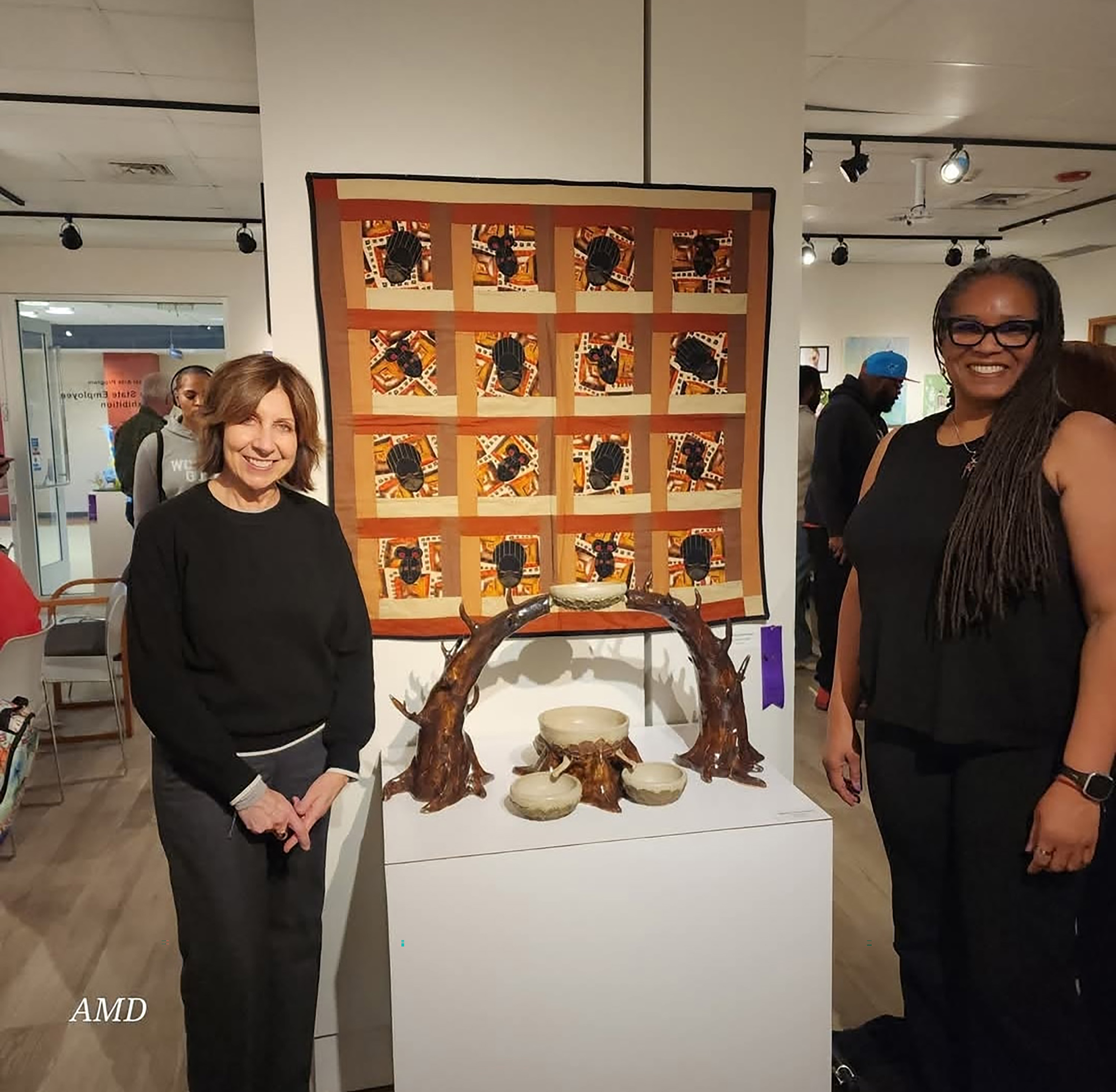 Dr. Adenike Davidson (r) stands next to her quilt work that won a Honorable Mention. Kristin Pleasanton stands with her.