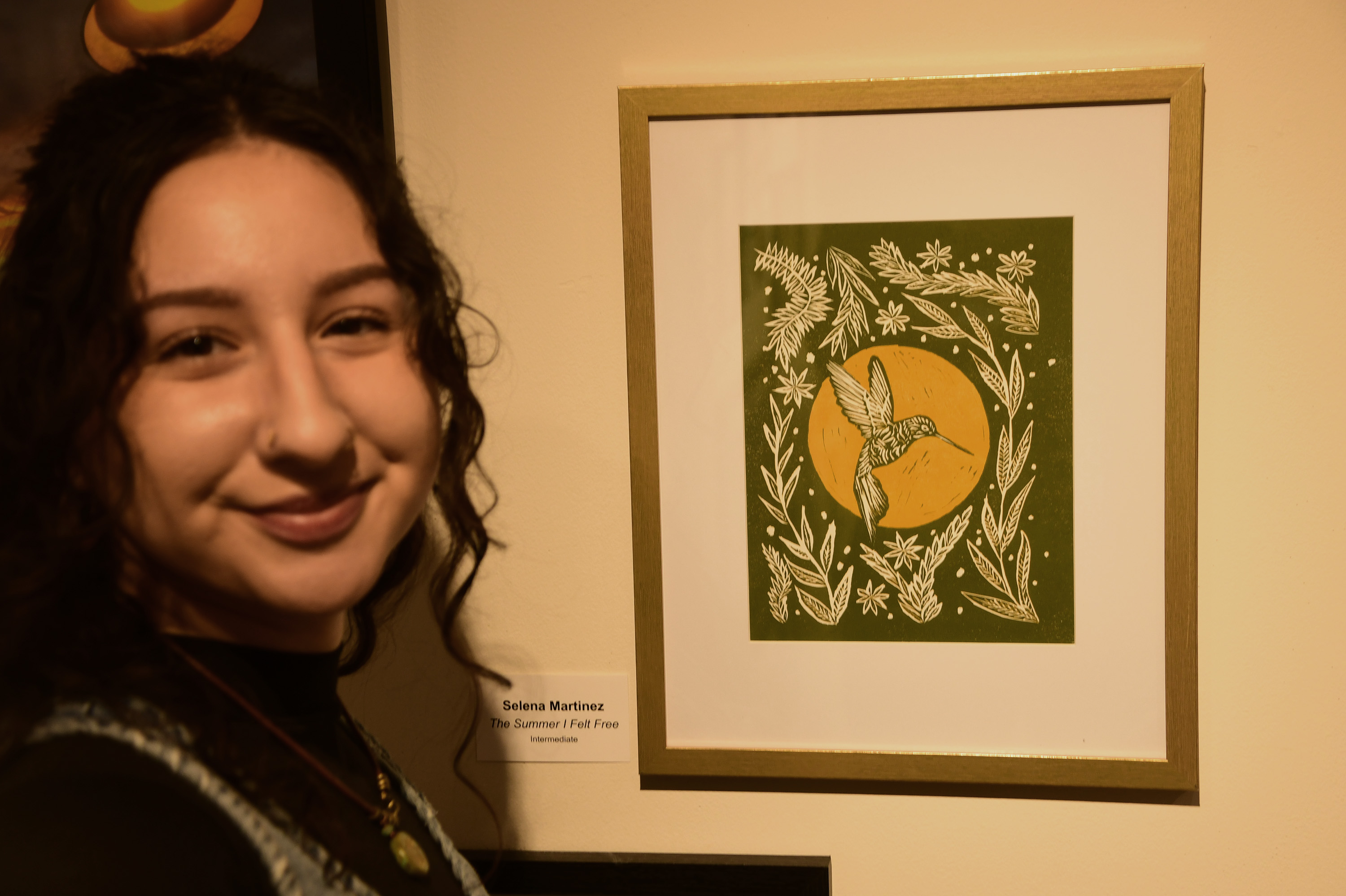 Selena Martinez, a DSU art student and an state employee at DNREC, poses with her "The Summer I Felt Free" work.