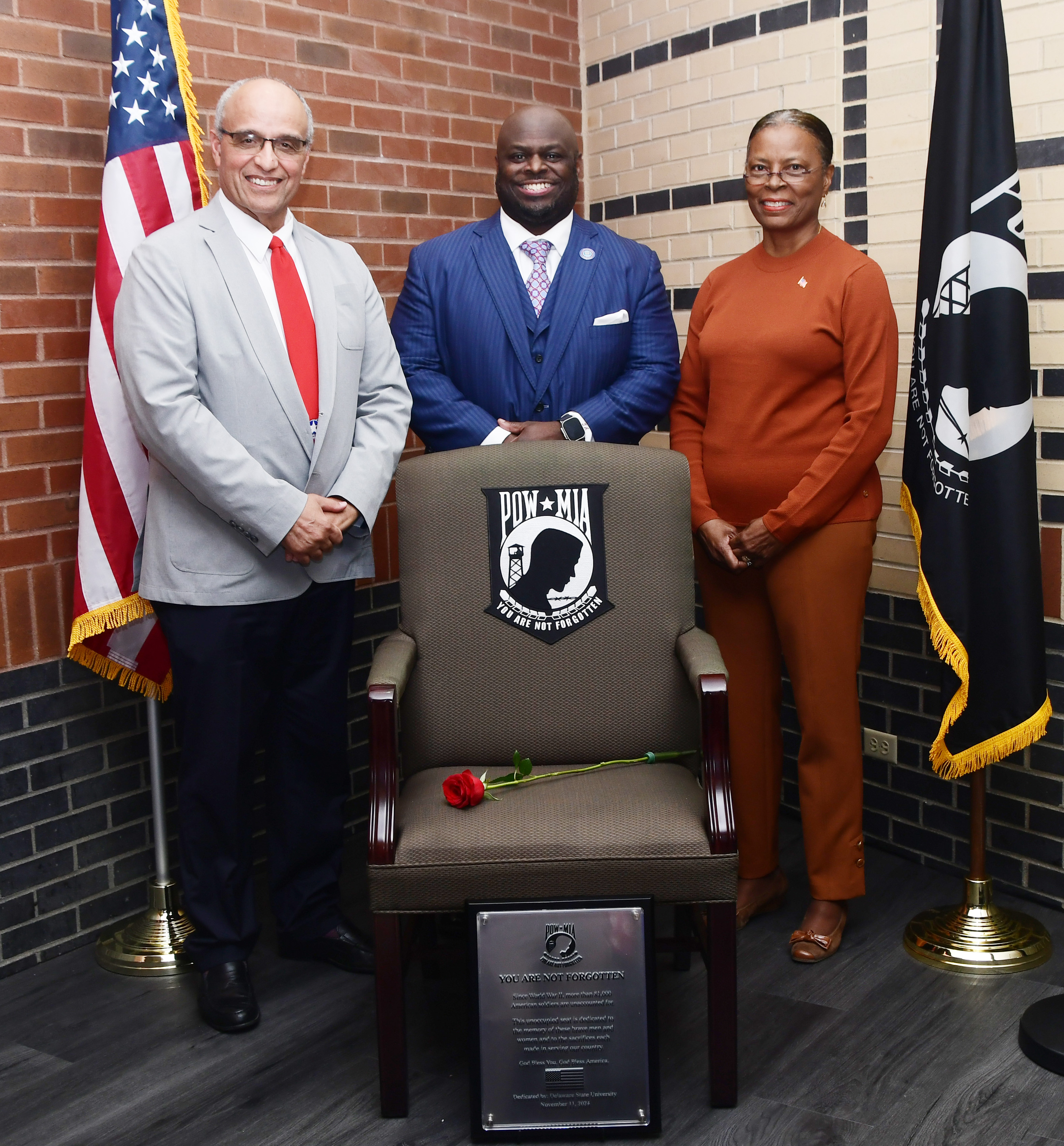 DSU President Tony Allen stands at the Chair of Honor with keynote speakers Andre Swygert and Col. (Ret.) Debbie Harrington.