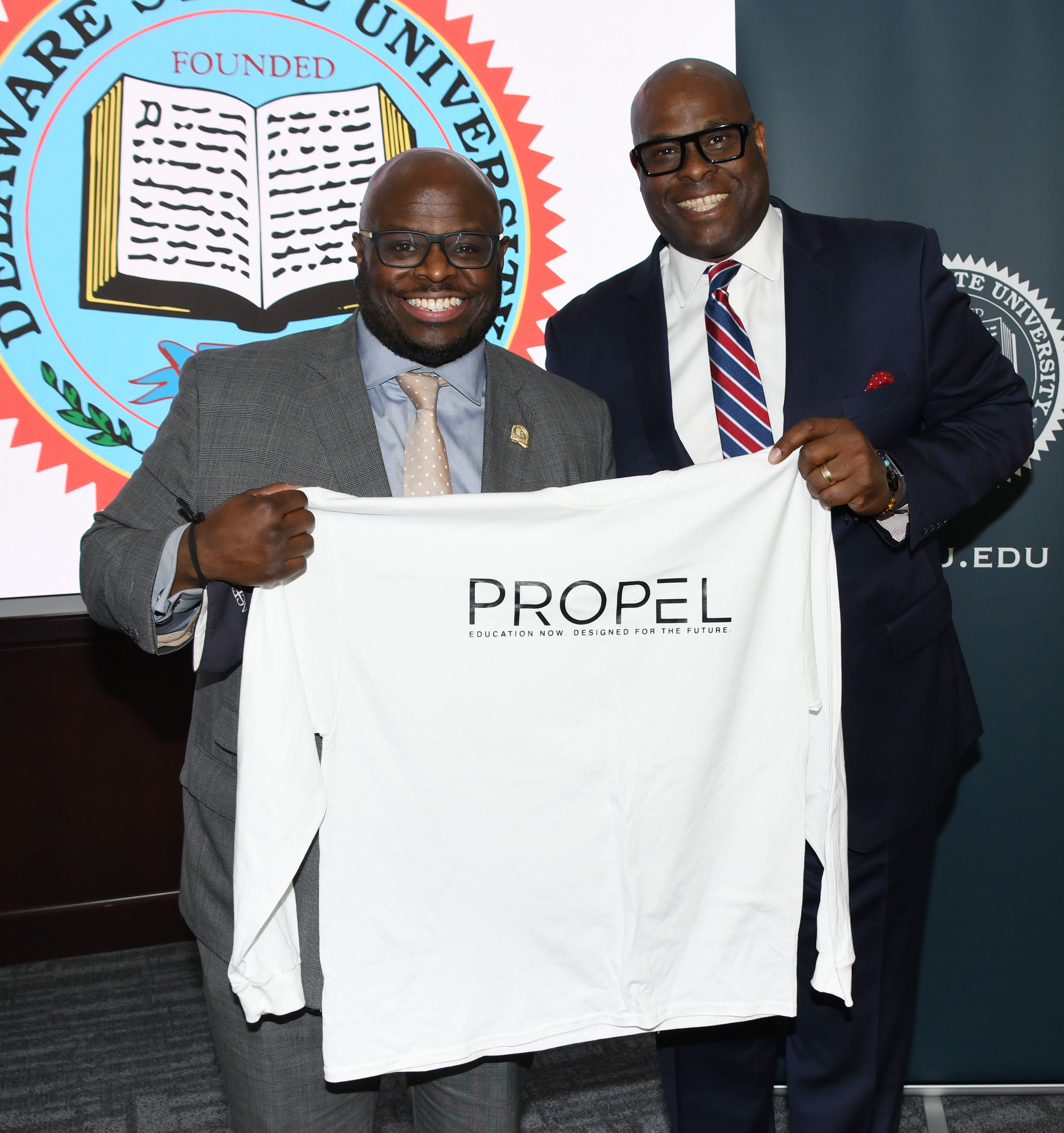 Dr. Charles  Gibbs (r) presents University President Tony Allen with a Propel Center t-shirt.