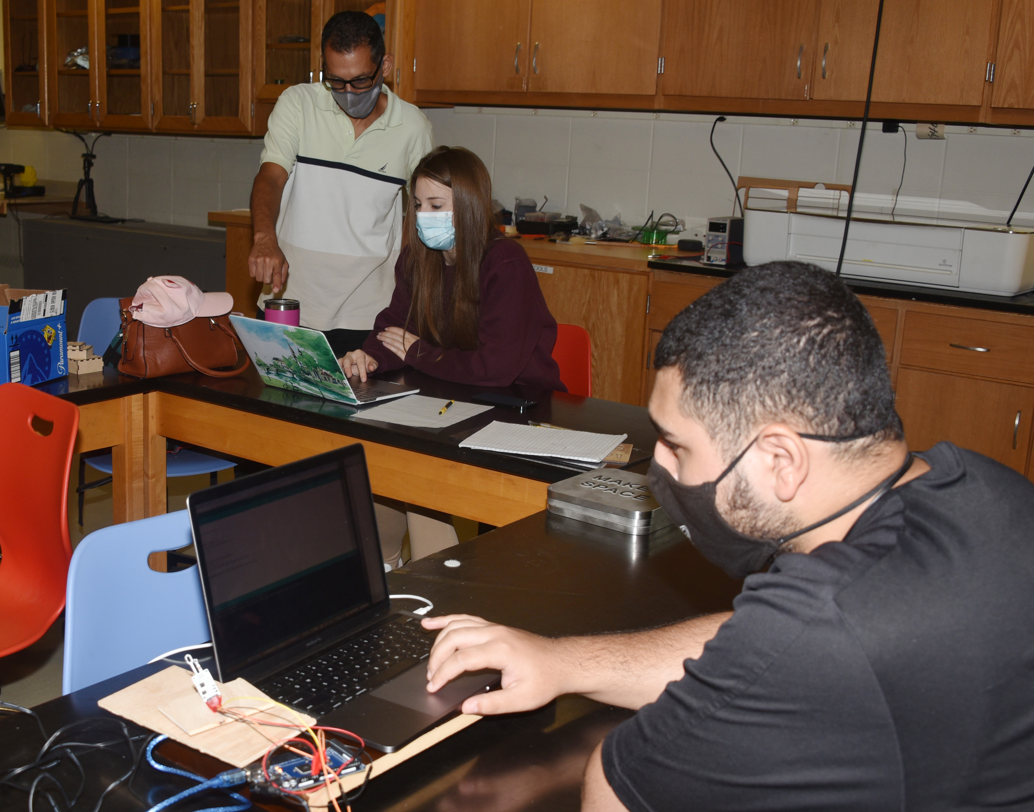(L-r) Dr. Marwan Rasamny provides guidance to Sabrina Kruger and Abdullah Al-Rubaye in the Maker Space.