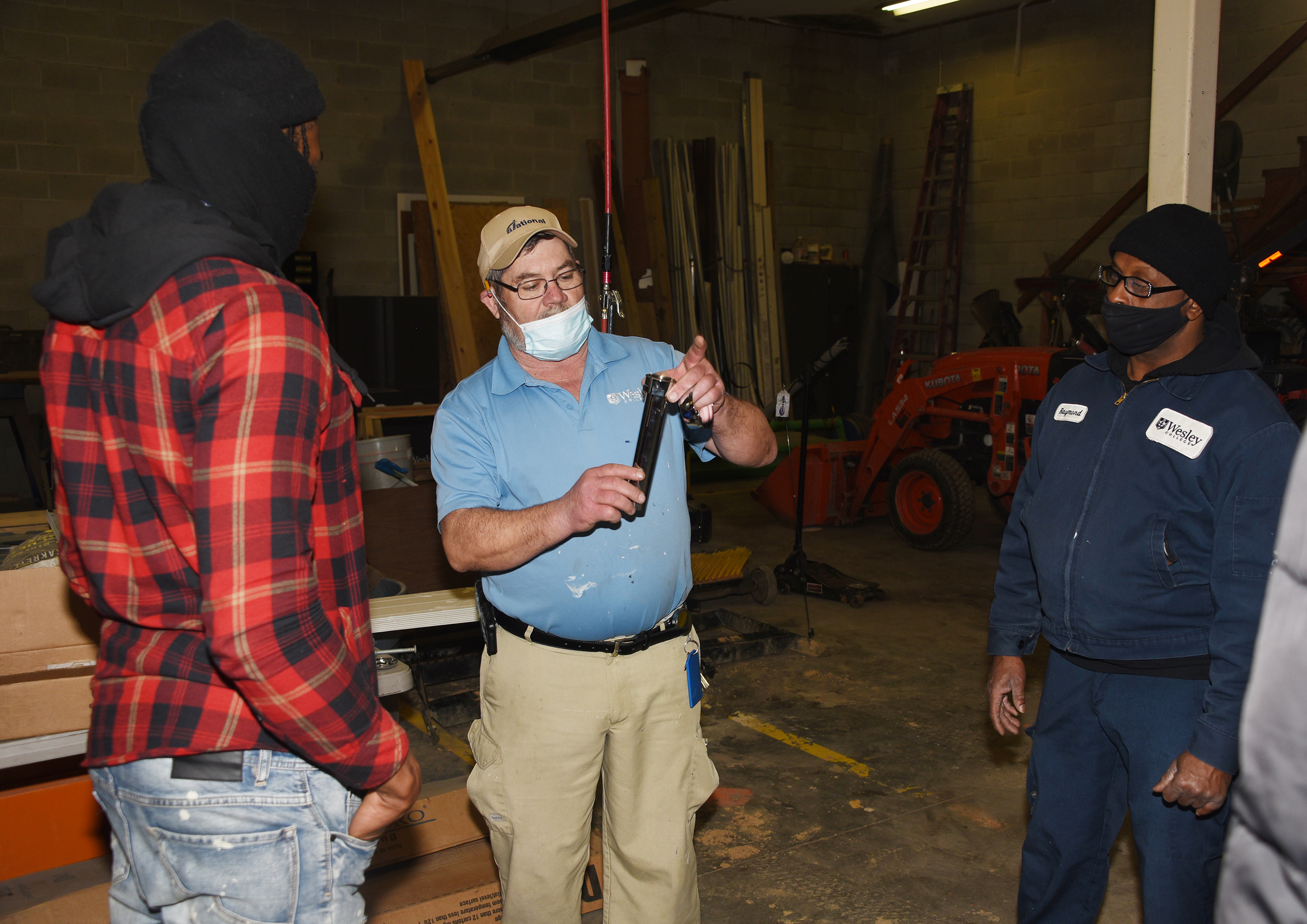 Frankie Martin, a Wesley College facilities worker, shares his plumbing knowledge with three P2A participants.