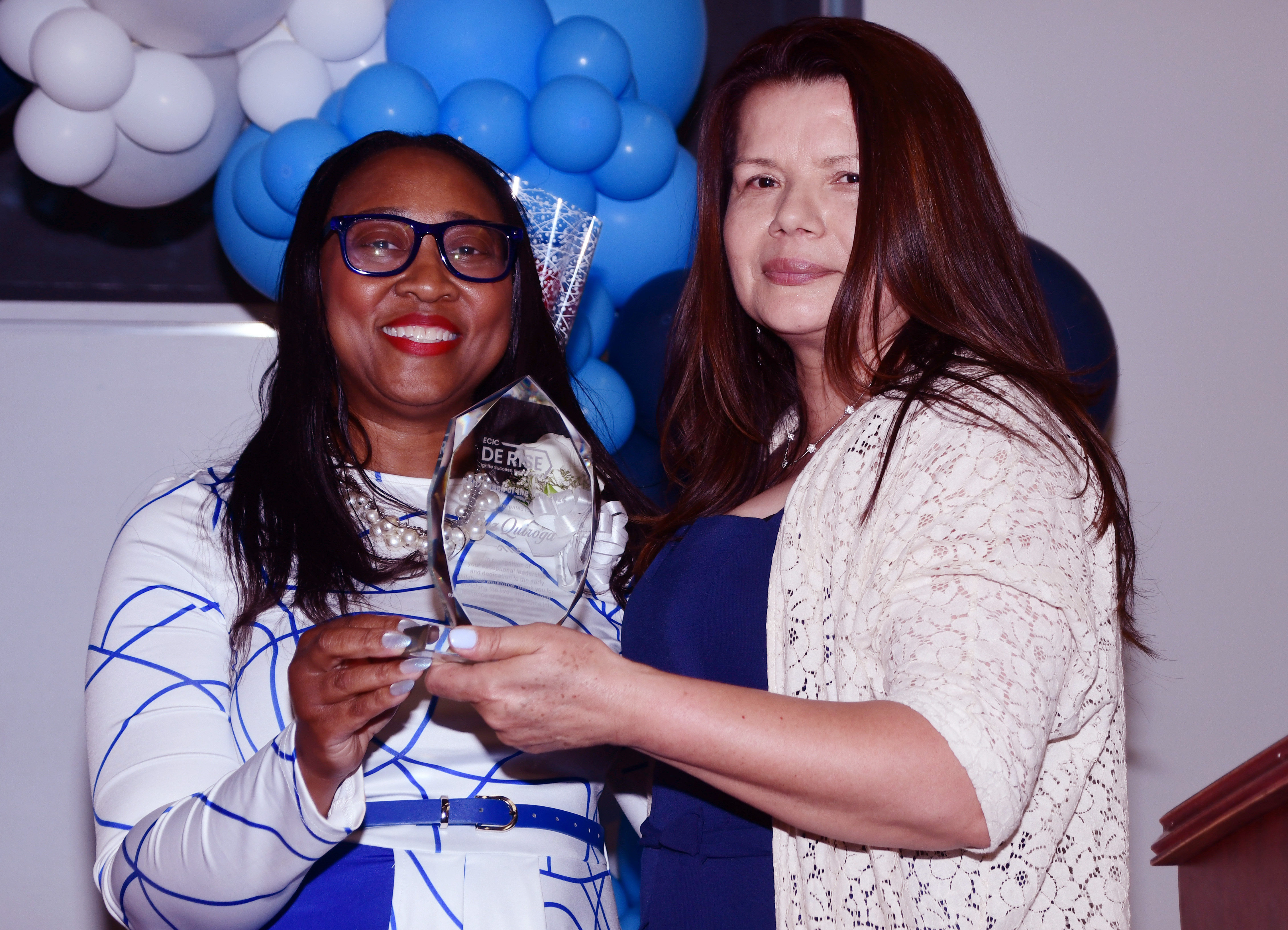 ECIC's Dionne Patterson presents Luz Quiroga (r) with the Coach of the Year Award.