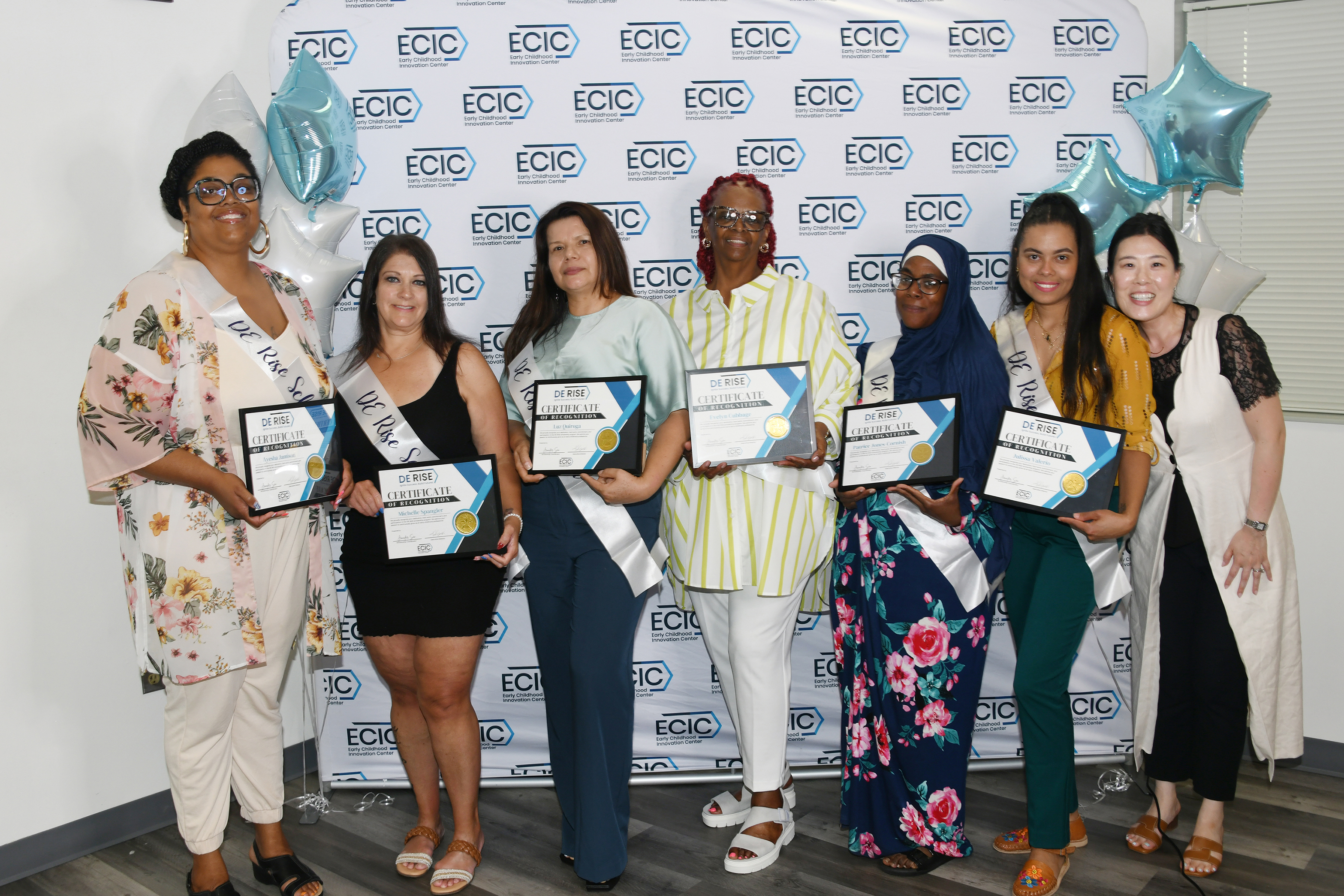 Ms. Quiroga (3rd from left) stand among the first group to earn higher education degrees thru the DE RISE Scholarship.
