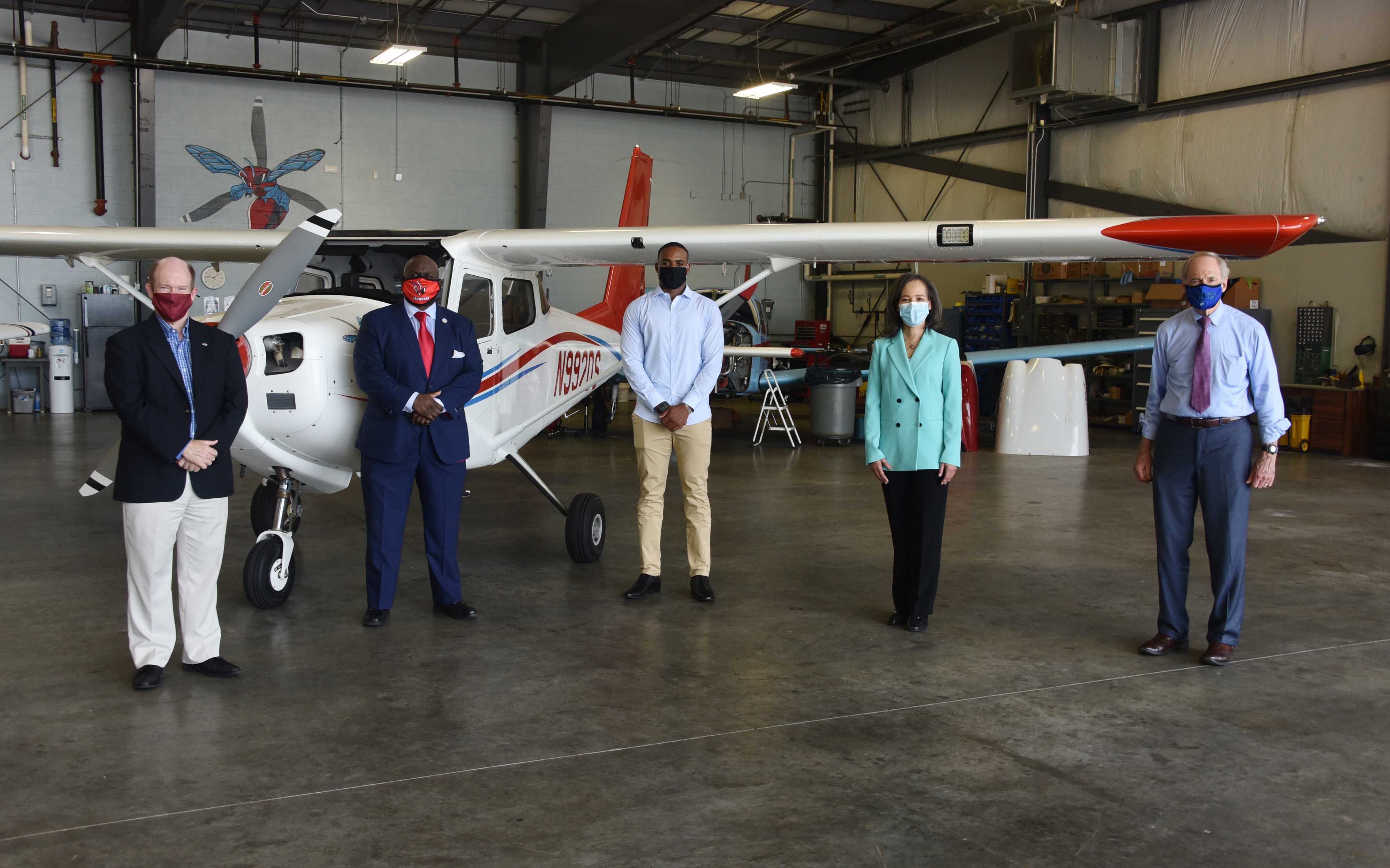 (L-r) U.S. Chris Coons, University President Tony Allen, Aviation freshman Tajay Kelly, U.S. Rep. Lisa Blunt Rochester, and U.S. Sen. Tom Carper pose with adherence to social distancing, after an event in the Daniel Coons Hanger at the Delaware Airpark where the talked about The Flight Act and how it would benefit Del State's Aviation Program.  