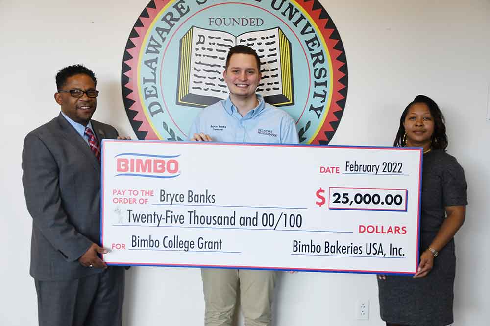 Bryce Banks, a sophomore Natural Resources/Wildlife Management major, celebrates receiving a $25,000 grant after winning a sweepstake conducted by Bimbo Bakeries to go toward his University expenses. Share the moment with Mr. Banks are Travis Sudler (l), Director of Enrollment Management Services and Aleasha Dorsett, Director of Annual Fund at Delaware State University.