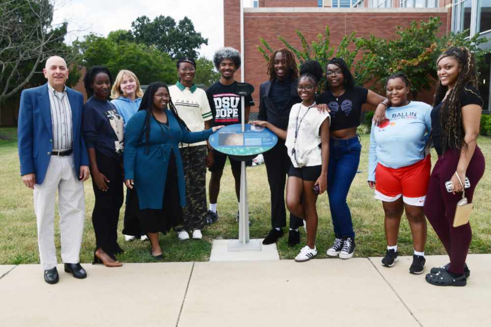 (L-r) Dr. Matt Bobrowsky, Chanel Beck, Isabella Gondola, Tyroniece Hampton-Jones, Adaeze Iwegbulam, Jaymen Morris, Galvin Pascal Mombrun, Morgan Boomer, Kenya Miller, Kaliya Garcia, and Sanaa Lemon-Siler stand at the Mercury station, one of 11 of the Voyage Scale Model Solar System exhibition stations permanently installed across the campus.