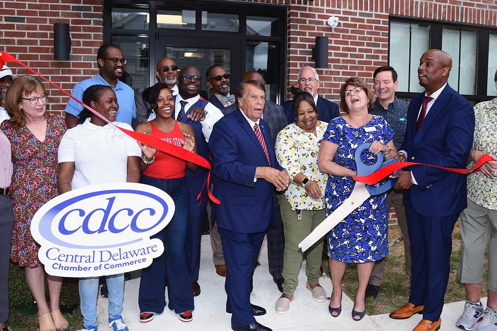 DSU President Tony Allen, Dover Mayor Robin Christiansen, NGP's Karen Speakman, Dr. Michael Casson and many other rejoice at the cutting of the ribbon at the new CURE Building on Division Street in Dover. The facility will include a business incubator designed to provide opportunities and resources for small businesses.