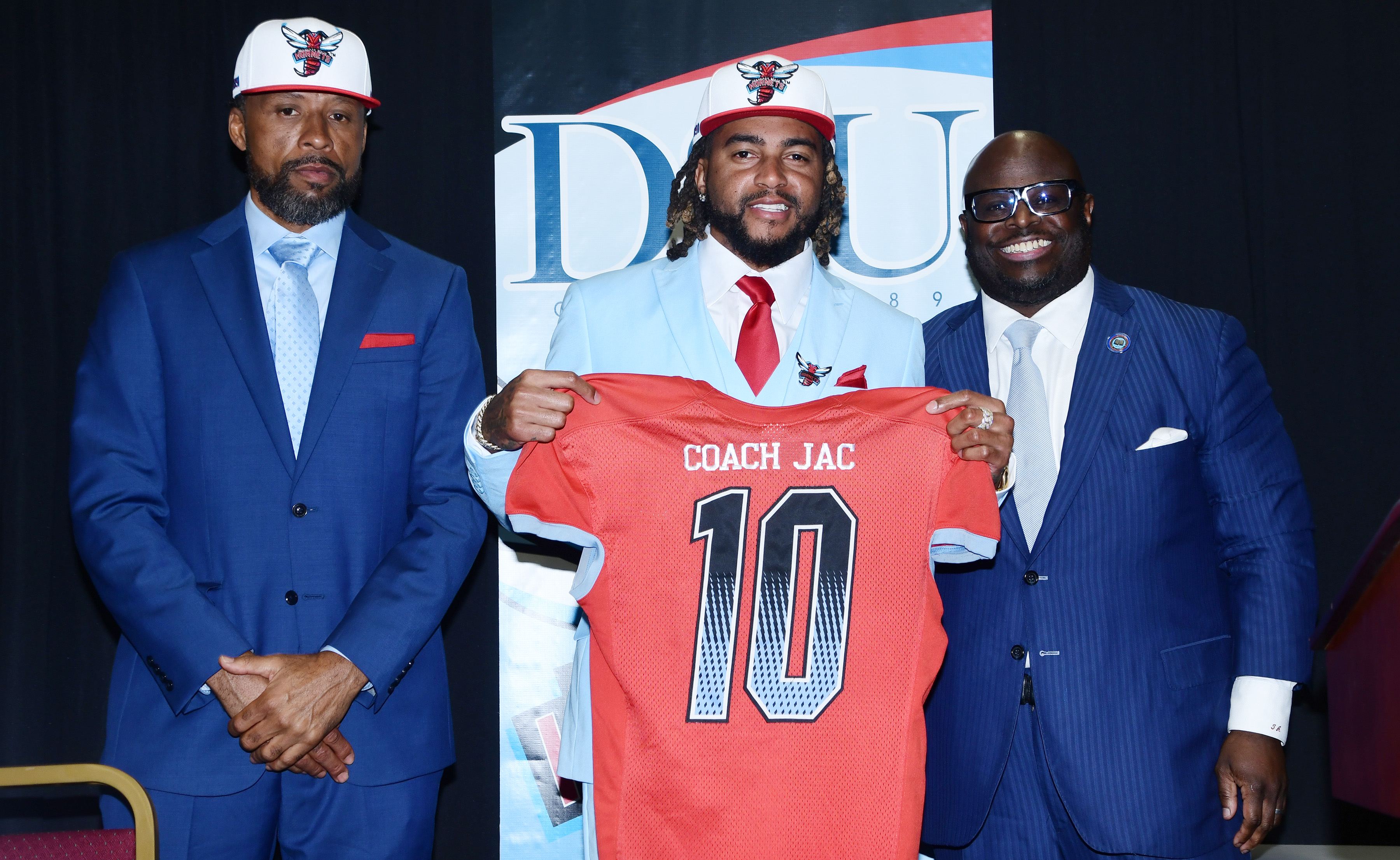 New DSU Head Football Coach DeSean Jackson holds up a jersey presented to him during the Jan. 8 media event to introduce him to the DSU and at-large communities. Flanking him are new Hornet Assistant Head Coach Travis Clark (l) and University President Tony Allen.