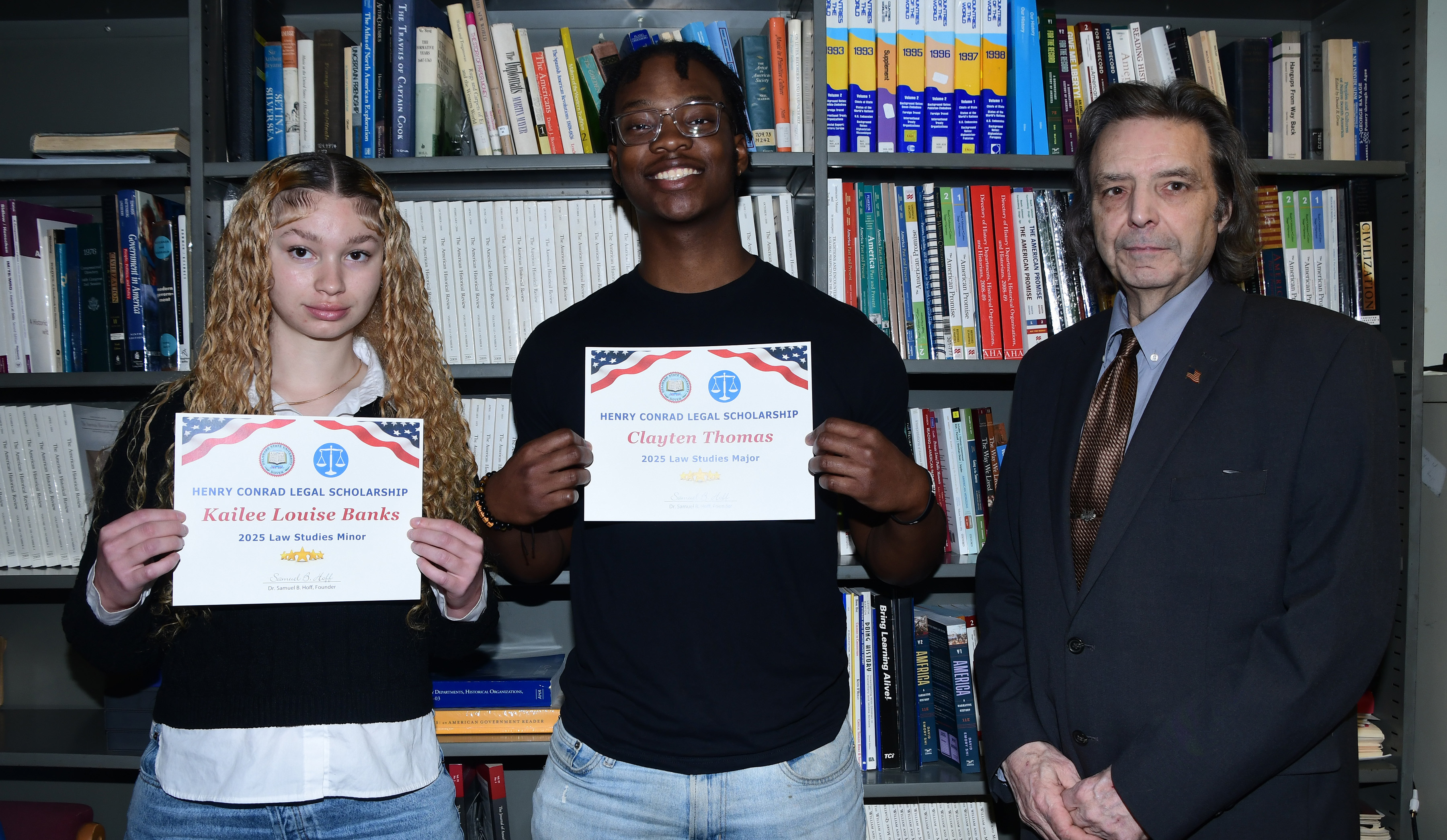 (L-r) Kailee Louise Banks and Clayten S. Thomas hold certificates affirming their receipt each of a $500 Henry Conrad Legal Scholar for maintaining the highest GPA among Law Studies majors and minors. Standing with them is Dr. Sam Hoff, Professor Emeritus of History, Political Science and Law Studies.