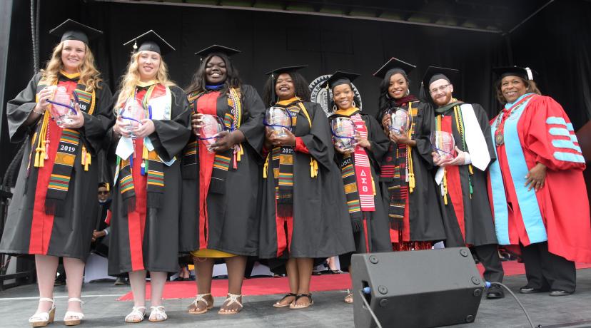 <p>Seven 4.0 GPA graduates -- (l-r) Micaela Cummings, Stephanie Lynn, Adriante Carter, Jazmyn Robinson Stockton, Jasmine Herring, Morgan Poole and Logan Faux-Dugan -- all received the Presidential Academic Award from University President Wilma Mishoe (far right).</p>
